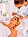 Woman middle-aged in spa salon. Tweezing eyebrow by beautician. Royalty Free Stock Photo