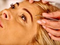 Woman middle-aged in spa salon. Tweezing eyebrow