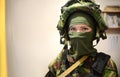 Woman in military clothes with mask over light background and with vignetting. Female soldier in camouflage Woman at war concept.