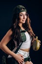 woman with military riot uniform in studio on dark background. A beautiful girl in short shorts and a white top holds a flask