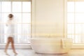 Woman in minimalistic white bathroom interior Royalty Free Stock Photo