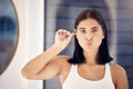 Woman, mirror and cleaning ear in morning in home, bathroom and self care for personal hygiene. Girl, health and beauty