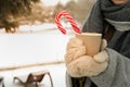 Woman in mittens hold cup of hot drink outdoor in winter Royalty Free Stock Photo
