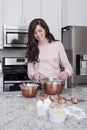 Woman mixing batter into bowls in the kitchen Royalty Free Stock Photo