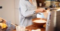Woman mixing daugh for baking waffles at home