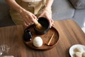 Woman whisking matcha green tea drink at home using tea ceremony set
