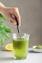 woman mixing water with green superfood powder