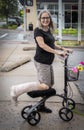 Woman on mobility scooter on street with leg wrapped smiling at camera Royalty Free Stock Photo