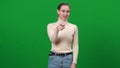 Woman mocking pointing at camera and laughing. portrait of young rude slim Caucasian lady sneering on green screen