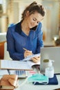 Woman at modern home in sunny day talking on phone and working Royalty Free Stock Photo