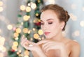 Woman with moisturizer over christmas lights Royalty Free Stock Photo
