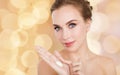 Woman with moisturizing cream on hand over lights Royalty Free Stock Photo