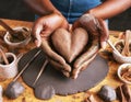 Woman molding heart from clay
