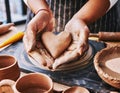 Woman molding a heart out of clay