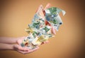 Woman with money on brown background, closeup. Currency exchange