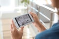 Woman monitoring modern cctv cameras on smartphone indoors