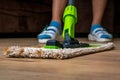 Woman with mop mopping wooden laminate floor