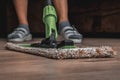 Woman with mop mopping wooden laminate floor