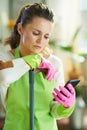 Woman with mop use clean app at modern home in sunny day Royalty Free Stock Photo