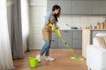 Woman mopping floor in bright kitchen interior Royalty Free Stock Photo