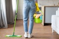 Woman mopping floor with green mop and carrying cleaning supplies Royalty Free Stock Photo