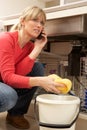 Woman Mopping Up Leaking Sink