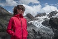 Woman at Morteratsch Glacier in the Engadin in the Swiss Alps in summer with blue sky and sun