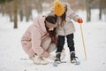 Woman mother helps her child stand children& x27;s skis Royalty Free Stock Photo