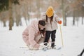 Woman mother helps her child stand children& x27;s skis Royalty Free Stock Photo