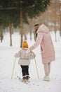 Woman mother helps her child stand children& x27;s skis Royalty Free Stock Photo