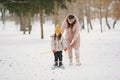 Woman mother helps her child stand children& x27;s skis Royalty Free Stock Photo