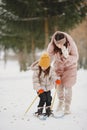 Woman mother helps her child stand children& x27;s skis Royalty Free Stock Photo