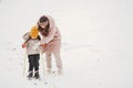 Woman mother helps her child stand children& x27;s skis Royalty Free Stock Photo