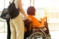 Woman with mother in wheelchair waiting for boarding at International airport.