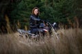 woman on a motorbike in nature. biker motorcycle ride through the woods