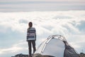 Woman on mountain cliff alone foggy clouds landscape