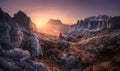 Woman on the mountain trail and stones at sunset in autumn