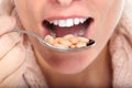 Woman mouth eating pills.