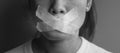 Woman with mouth sealed in adhesive tape. Free of speech, freedom of press, Human rights, Protest dictatorship, democracy, liberty