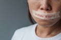 Woman with mouth sealed in adhesive tape with Human rights message. Free of speech, freedom of press, Protest dictatorship,