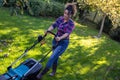 Woman mowing lawn in garden Royalty Free Stock Photo