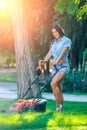Woman mowing lawn in residential back garden on Royalty Free Stock Photo