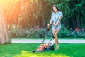 Woman mowing lawn in residential back garden Royalty Free Stock Photo