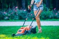 Woman mowing lawn in residential back garden Royalty Free Stock Photo