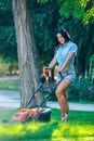 Woman mowing lawn in residential back garden Royalty Free Stock Photo