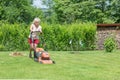 Woman mows the grass in the garden