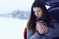 Woman with mug of hot drink in winter forest Royalty Free Stock Photo