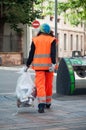 Woman municipal employee taking garbage in hand