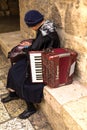 Woman musician accordion calculates earnings in one of the corners of the Jewish quarter of the old city. Jerusalem,