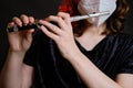 Woman musician with flute in medical face mask on studio black background. Problems of playing at concerts during quarantine Royalty Free Stock Photo